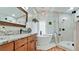 Bright bathroom featuring a soaking tub, walk-in shower, wood cabinets, and elegant finishes at 9403 9Th Nw Ave, Bradenton, FL 34209