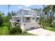 Charming two-story coastal home with a white exterior, multiple balconies, and a spacious driveway at 9403 9Th Nw Ave, Bradenton, FL 34209