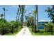 Long driveway leading to a two-story coastal home, set among tall palm trees and lush landscaping at 9403 9Th Nw Ave, Bradenton, FL 34209