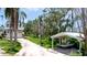 Exterior view of home with a driveway, lush landscaping, covered parking area and docked boat at 9403 9Th Nw Ave, Bradenton, FL 34209
