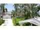 Exterior view of home featuring a spacious driveway, lush tropical landscaping, and a charming gazebo at 9403 9Th Nw Ave, Bradenton, FL 34209