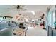 Bright, open-concept living room featuring a large grey sofa, skylight, and seamless flow to the dining area at 9403 9Th Nw Ave, Bradenton, FL 34209