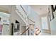 Elegant staircase with white railings, wood steps, and natural light streaming through the window at 9403 9Th Nw Ave, Bradenton, FL 34209