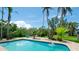 Gorgeous pool with beautiful landscaping, poolside seating, and tall palm trees, creating a private oasis at 9403 9Th Nw Ave, Bradenton, FL 34209
