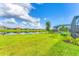 Scenic backyard view featuring a serene pond, lush greenery, and neighboring homes at 3025 Veneto Ct, Bradenton, FL 34211