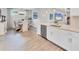 Modern kitchen features an island with stainless steel appliances, white cabinetry, and an adjacent dining area at 3025 Veneto Ct, Bradenton, FL 34211