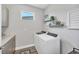 Efficient laundry room with modern washer, dryer, countertops and convenient upper shelving at 3025 Veneto Ct, Bradenton, FL 34211