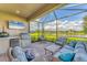 Screened in patio with outdoor kitchen, comfortable seating, and a beautiful lake view at 3025 Veneto Ct, Bradenton, FL 34211