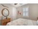 Bedroom with coastal decor featuring a round mirror, palm ceiling fan, and window with white shutters at 11200 Whimbrel Ln, Sarasota, FL 34238
