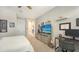Bedroom featuring plantation shutters, tv, and nearby workspace at 11200 Whimbrel Ln, Sarasota, FL 34238
