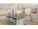 Gourmet kitchen featuring a large island, pendant lighting, white cabinetry, and stainless steel appliances at 11200 Whimbrel Ln, Sarasota, FL 34238