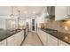 A modern kitchen with stainless steel appliances, a sleek cooktop, and granite countertops at 11200 Whimbrel Ln, Sarasota, FL 34238