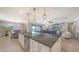 Open concept kitchen island with granite countertops and stainless steel dishwasher overlooking the living area at 11200 Whimbrel Ln, Sarasota, FL 34238