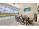 Outdoor patio dining area featuring a pool, exterior TV, and decorative light fixture at 11200 Whimbrel Ln, Sarasota, FL 34238