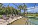 Relaxing screened-in pool area with comfortable lounge chairs and tropical landscaping at 11200 Whimbrel Ln, Sarasota, FL 34238