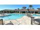 Community pool and hot tub surrounded by tables, chairs and umbrellas at 11200 Whimbrel Ln, Sarasota, FL 34238