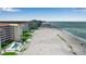 Expansive beachside condos, showcasing pristine sandy shoreline and turquoise ocean views under a partly cloudy sky at 1150 Tarpon Center Dr # 1-C 103, Venice, FL 34285