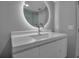 Bright bathroom with round backlit mirror, modern vanity with sink, and glass-enclosed shower at 1150 Tarpon Center Dr # 1-C 103, Venice, FL 34285