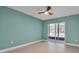 Bedroom with light wood floors, ceiling fan, and sliding glass door to the balcony at 1150 Tarpon Center Dr # 1-C 103, Venice, FL 34285