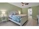Well-lit bedroom with calming green walls, a ceiling fan, and an ensuite bathroom at 1150 Tarpon Center Dr # 1-C 103, Venice, FL 34285