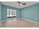 Bedroom with light wood floors, ceiling fan, and sliding glass door to the balcony at 1150 Tarpon Center Dr # 1-C 103, Venice, FL 34285