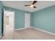 Cozy bedroom features wood floors, ceiling fan, and doorway to a bathroom at 1150 Tarpon Center Dr # 1-C 103, Venice, FL 34285