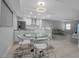 Bright, modern dining area featuring a glass table, sleek white chairs, and an open-concept layout at 1150 Tarpon Center Dr # 1-C 103, Venice, FL 34285