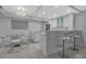 Modern kitchen featuring a marble-topped bar, sleek white cabinetry, and stainless steel appliances for a clean, minimalist look at 1150 Tarpon Center Dr # 1-C 103, Venice, FL 34285
