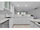 Contemporary kitchen with white cabinets, marble countertops, and a view into the living space at 1150 Tarpon Center Dr # 1-C 103, Venice, FL 34285