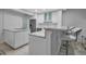 Modern kitchen featuring a marble-topped bar, sleek white cabinetry, and stainless steel appliances for a clean, minimalist look at 1150 Tarpon Center Dr # 1-C 103, Venice, FL 34285