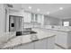 Bright kitchen showcasing marble countertops, stainless steel appliances, and sleek white cabinets at 1150 Tarpon Center Dr # 1-C 103, Venice, FL 34285
