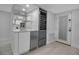 Contemporary bar area equipped with a wine fridge, sink, and modern shelving, adjacent to the kitchen at 1150 Tarpon Center Dr # 1-C 103, Venice, FL 34285