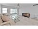 Bright living room featuring modern decor, light wood floors, and a sliding glass door to the balcony at 1150 Tarpon Center Dr # 1-C 103, Venice, FL 34285