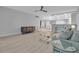Open-concept living room with wood flooring, glass coffee table, and an adjacent dining area with bar seating at 1150 Tarpon Center Dr # 1-C 103, Venice, FL 34285