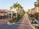 A scenic street with palm trees lining the road and charming buildings on either side at 1150 Tarpon Center Dr # 1-C 103, Venice, FL 34285