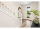 Entryway with white staircase, wood floors, a decorative mirror, and a plant creating a welcoming atmosphere at 12017 Cranston Way, Bradenton, FL 34211