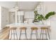 A well-lit kitchen featuring a breakfast bar with wooden stools, stainless steel appliances, and pendant lights at 12017 Cranston Way, Bradenton, FL 34211