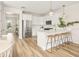 Open-concept kitchen with stainless appliances, white cabinetry, breakfast bar with wooden stools, and wood-look floors at 12017 Cranston Way, Bradenton, FL 34211