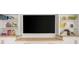 Entertainment room with large black TV surrounded by white built-in shelving and wooden counters at 12017 Cranston Way, Bradenton, FL 34211