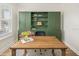Well-appointed office featuring custom green built-ins, a modern desk, and plush area rug at 12017 Cranston Way, Bradenton, FL 34211