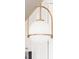 Close-up of a stylish pendant light with a gold frame and white globe, hanging above the kitchen island at 12017 Cranston Way, Bradenton, FL 34211