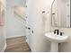 Elegant powder room features a pedestal sink, modern faucet, and stylish mirror at 12017 Cranston Way, Bradenton, FL 34211