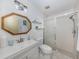 Bathroom features a glass enclosed shower, octagon mirror, a decorative light fixture, and a white sink and toilet at 154 Inlets Blvd, Nokomis, FL 34275