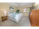 Bright bedroom with a king bed, woven furnishings, neutral carpet, and a large window with wood blinds at 154 Inlets Blvd, Nokomis, FL 34275