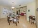 Dining room with glass table open to living room with modern decor and wood floors at 154 Inlets Blvd, Nokomis, FL 34275