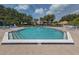 Community pool is surrounded by brick and has lounge chairs and beautiful blue umbrellas at 154 Inlets Blvd, Nokomis, FL 34275