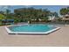 Community pool and spa surrounded by brick with lounge chairs, palm trees, and building at 154 Inlets Blvd, Nokomis, FL 34275