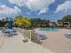 Community pool with lounge chairs, seating area, and lush landscaping on a bright day at 154 Inlets Blvd, Nokomis, FL 34275