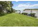 Wide backyard with green lawn, showcasing the side and rear of the mobile home at 170 Edgewood Dr, Osprey, FL 34229