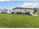 Exterior view showing the side of the house and the backyard, with neatly trimmed bushes at 170 Edgewood Dr, Osprey, FL 34229